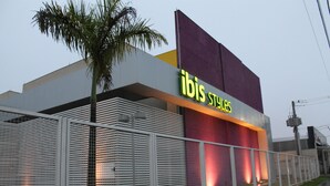 Un edificio moderno con un llamativo letrero de 'ibis Styles'.