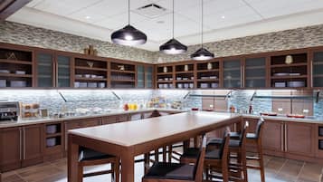 A modern kitchen with a central island, pendant lighting, and a backsplash with a geometric pattern.