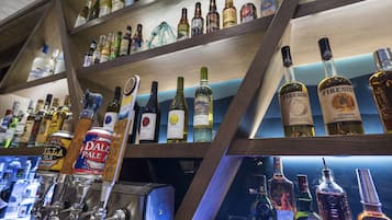 Eine Bar mit mehreren Regalen voller Spirituosenflaschen und einem Zapfbereich mit verschiedenen Biersäulen.