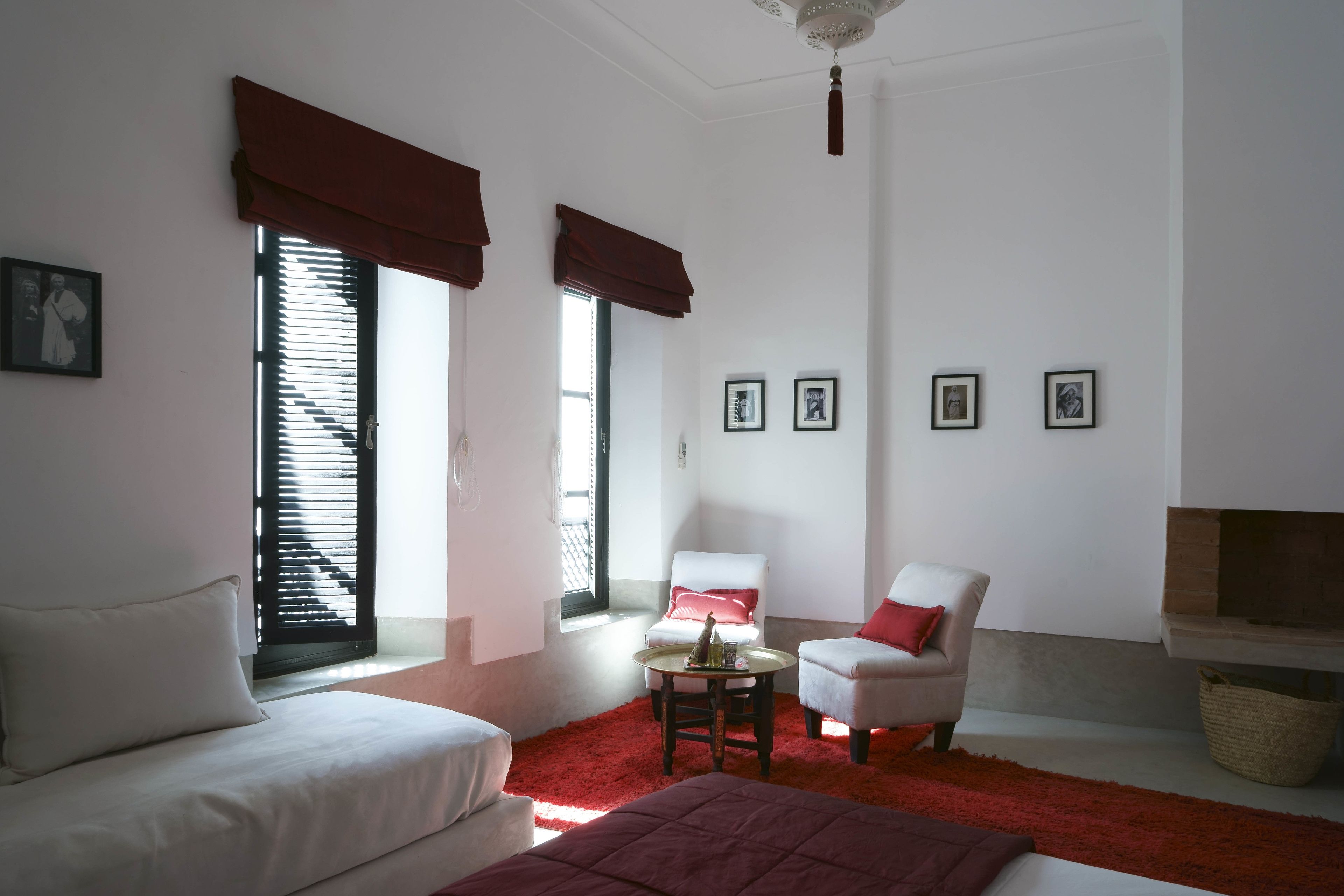 Una habitación con cama, dos sillones, una mesita y chimenea.