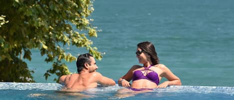 Seasonal outdoor pool, an infinity pool, pool umbrellas, pool loungers