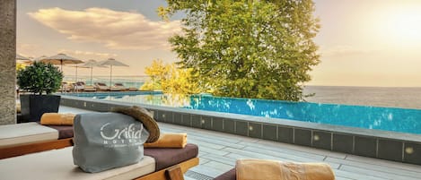 Seasonal outdoor pool, an infinity pool, pool umbrellas, pool loungers