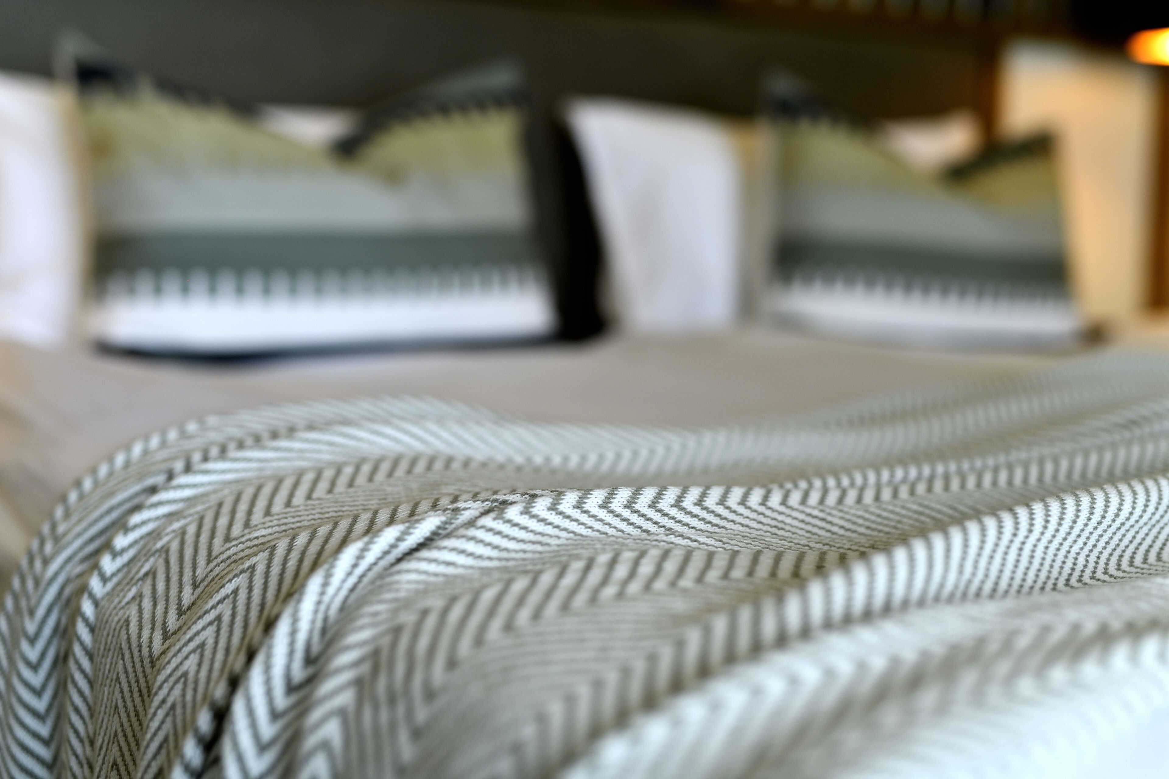 A bed with a patterned bedspread and pillows.