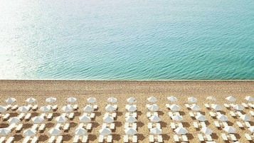 Sur la plage, chaise longue, parasol, serviettes de plage