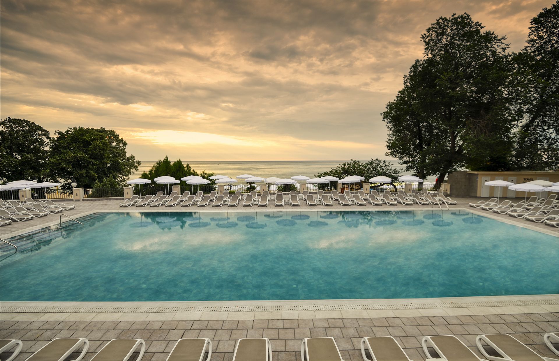 Piscine couverte, piscine extérieure, parasols de plage, chaises longues