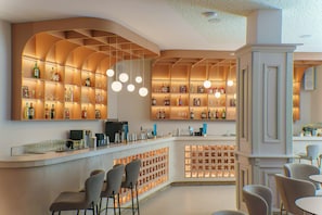 A bar area with shelves of bottles, a coffee machine, and seating. - Grifid Arabella Hotel - Ultra All inclusive & Aquapark (Golden Sands)
