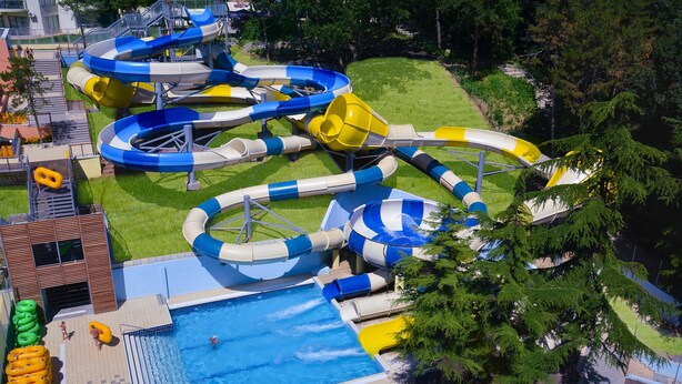 Ein Wasserpark mit mehreren Rutschen und einem Schwimmbecken.