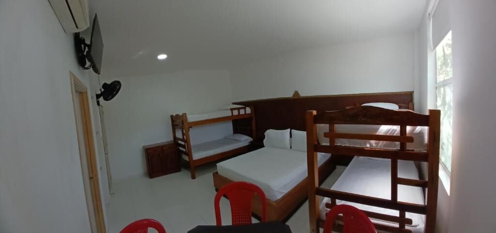 Una habitación con literas, un escritorio y una silla.