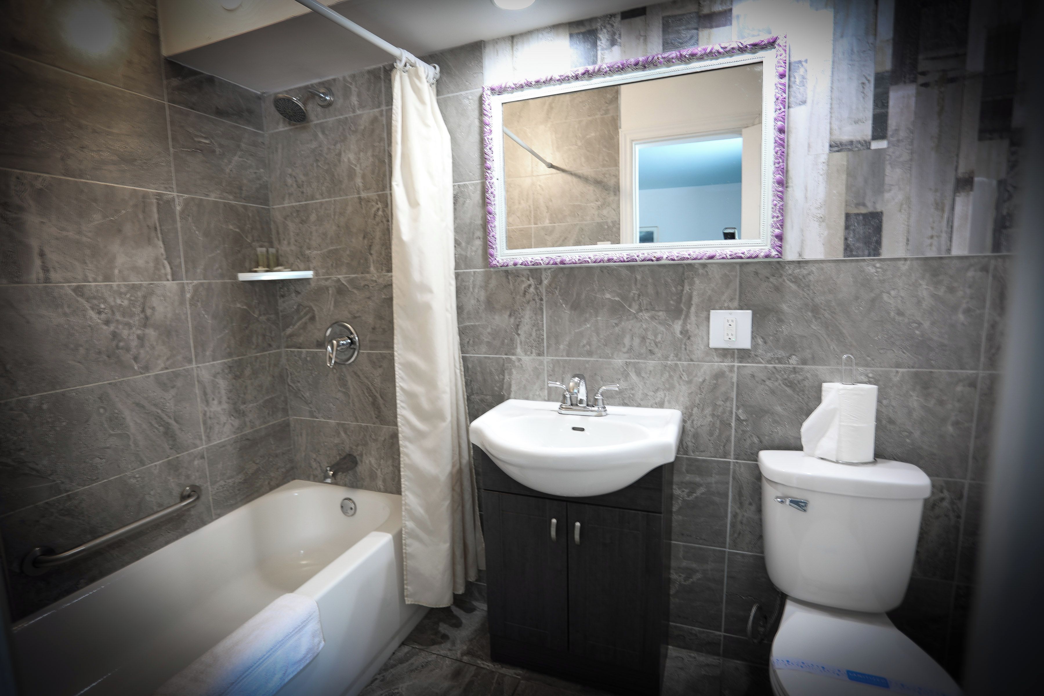 Un baño con bañera, lavamanos e inodoro.