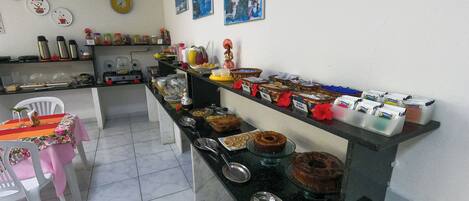 Una barra de buffet con distintos alimentos y salsas.