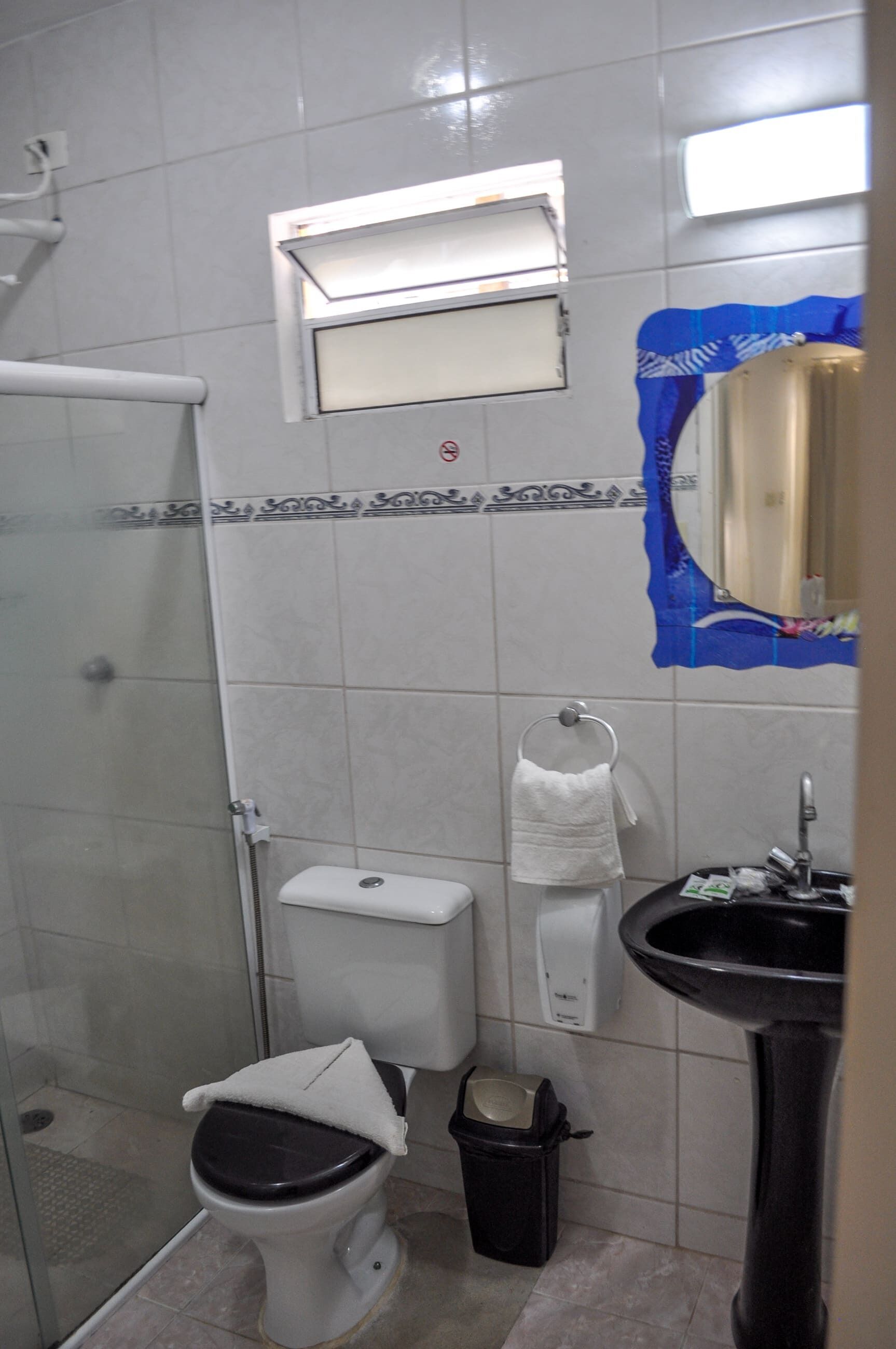 A small bathroom with a toilet, sink, and a shower area.