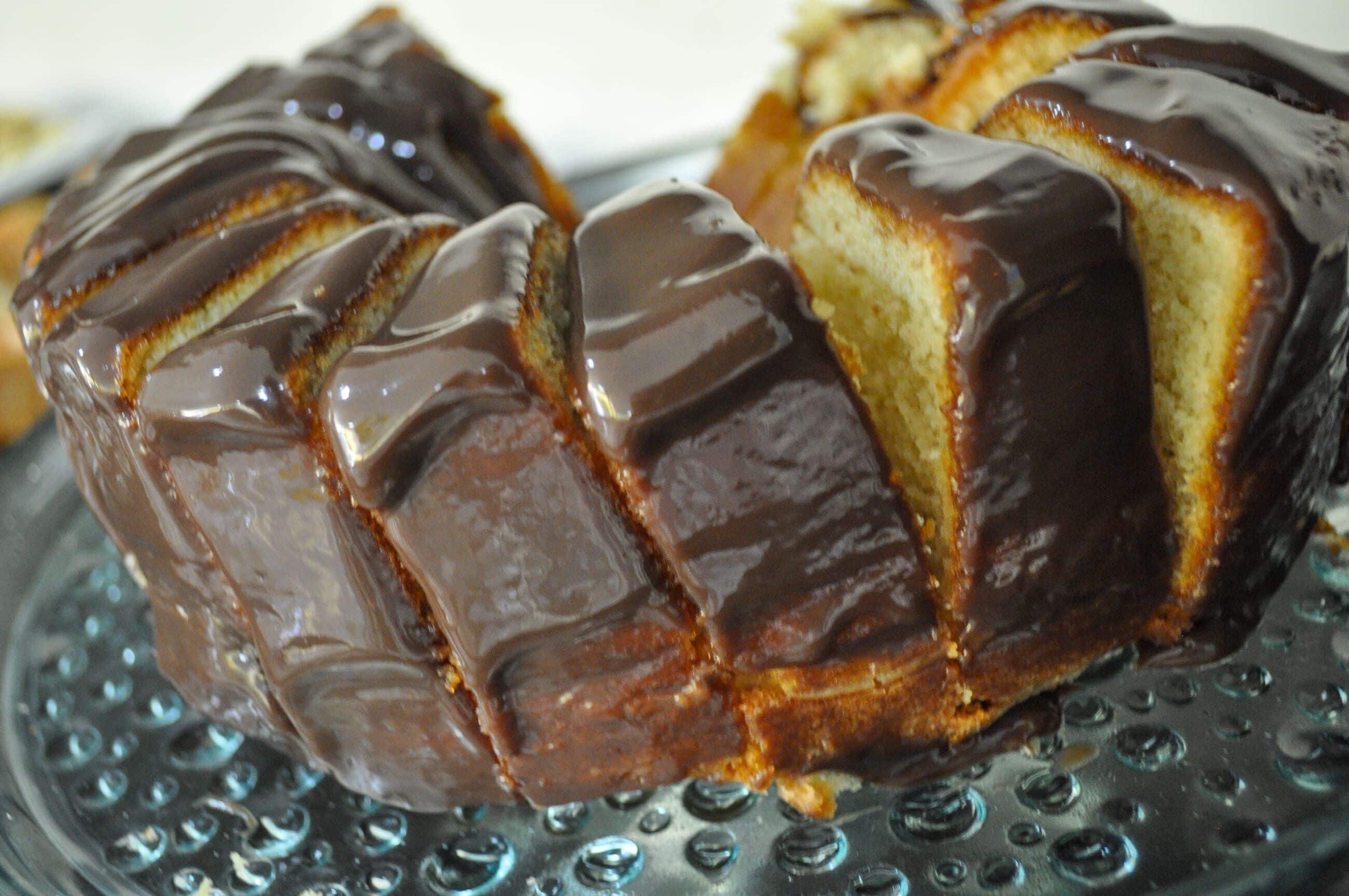 A chocolate-covered bundt cake on a glass plate.