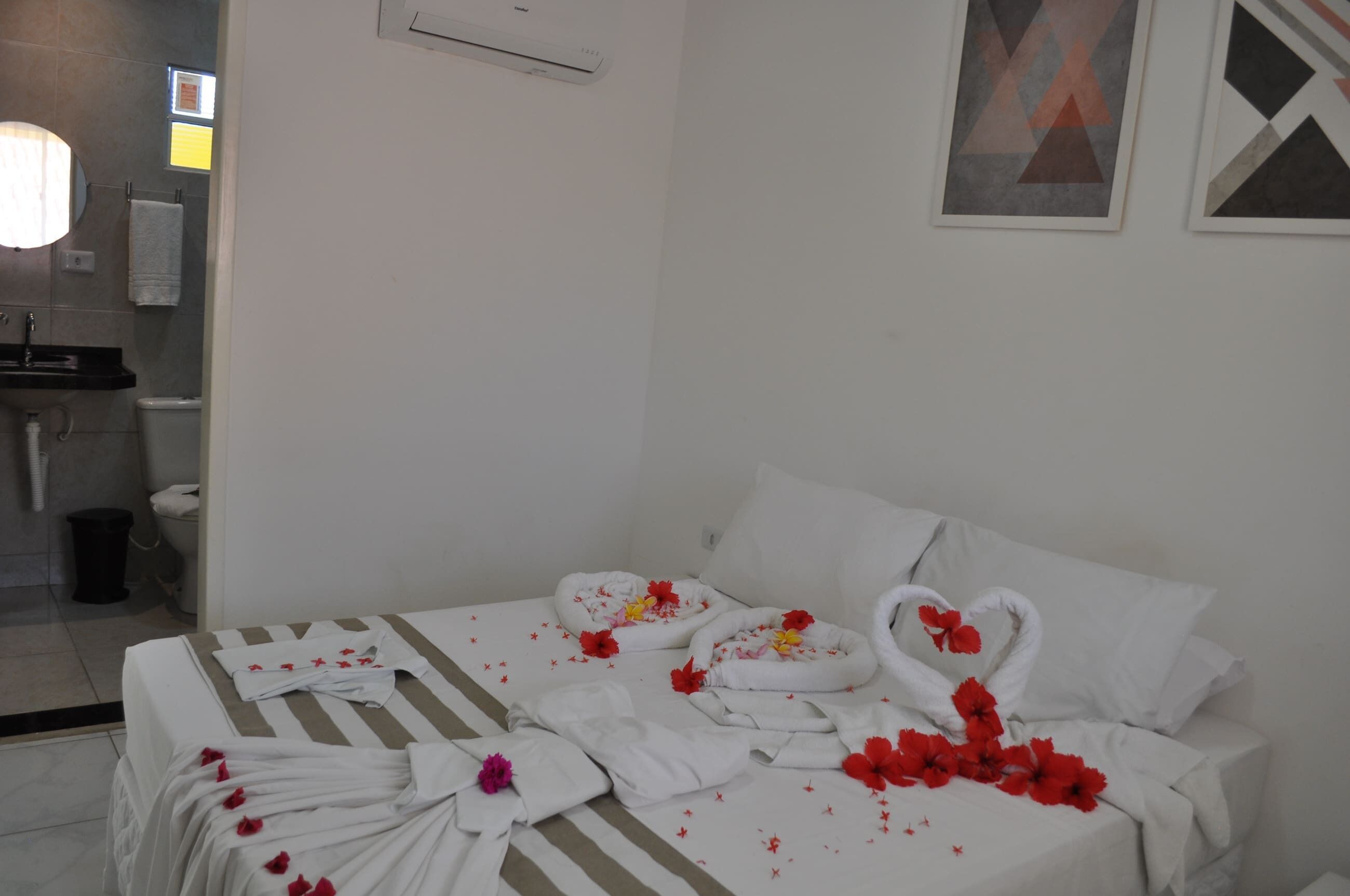 A hotel room with a bed, a bathroom, and a wall-mounted air conditioner.