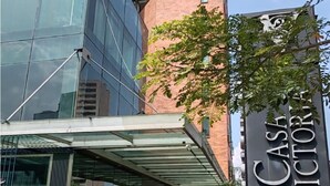 A hotel entrance with a modern glass facade, a brick tower, and a sign reading "Casa Victoria." - Hotel Casa Victoria Medellín (Medellín)