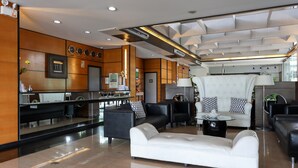 A modern lobby with a reception desk, seating area, and a large window. - Technopark Hotel (Santa Rosa)