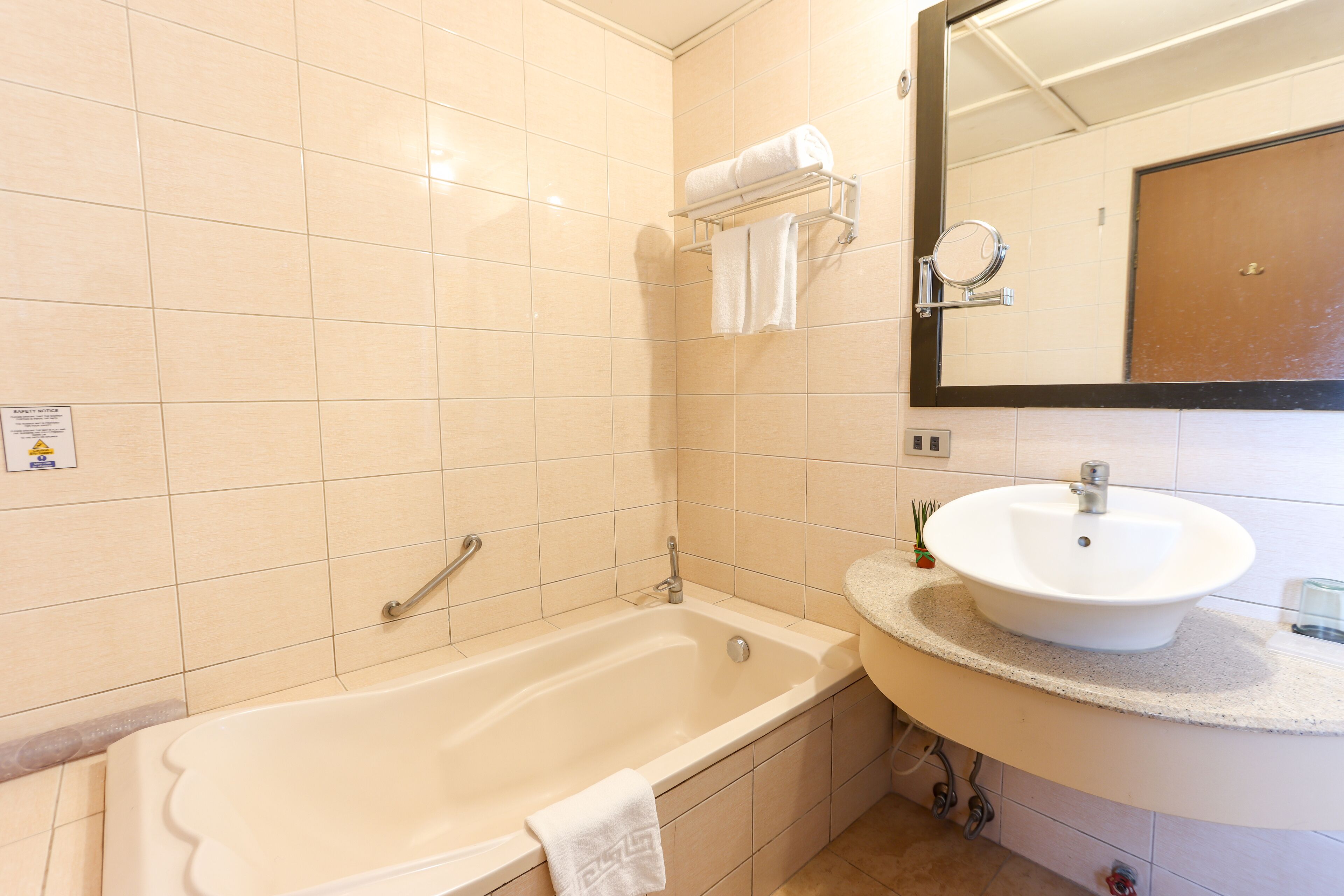 Een badkamer met een bad, een wastafel en een spiegel.