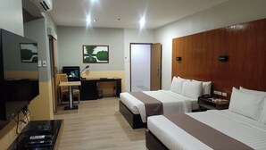 A hotel room with two beds, a desk, a chair, a TV, and a small table with electronic devices. - Technopark Hotel (Santa Rosa)
