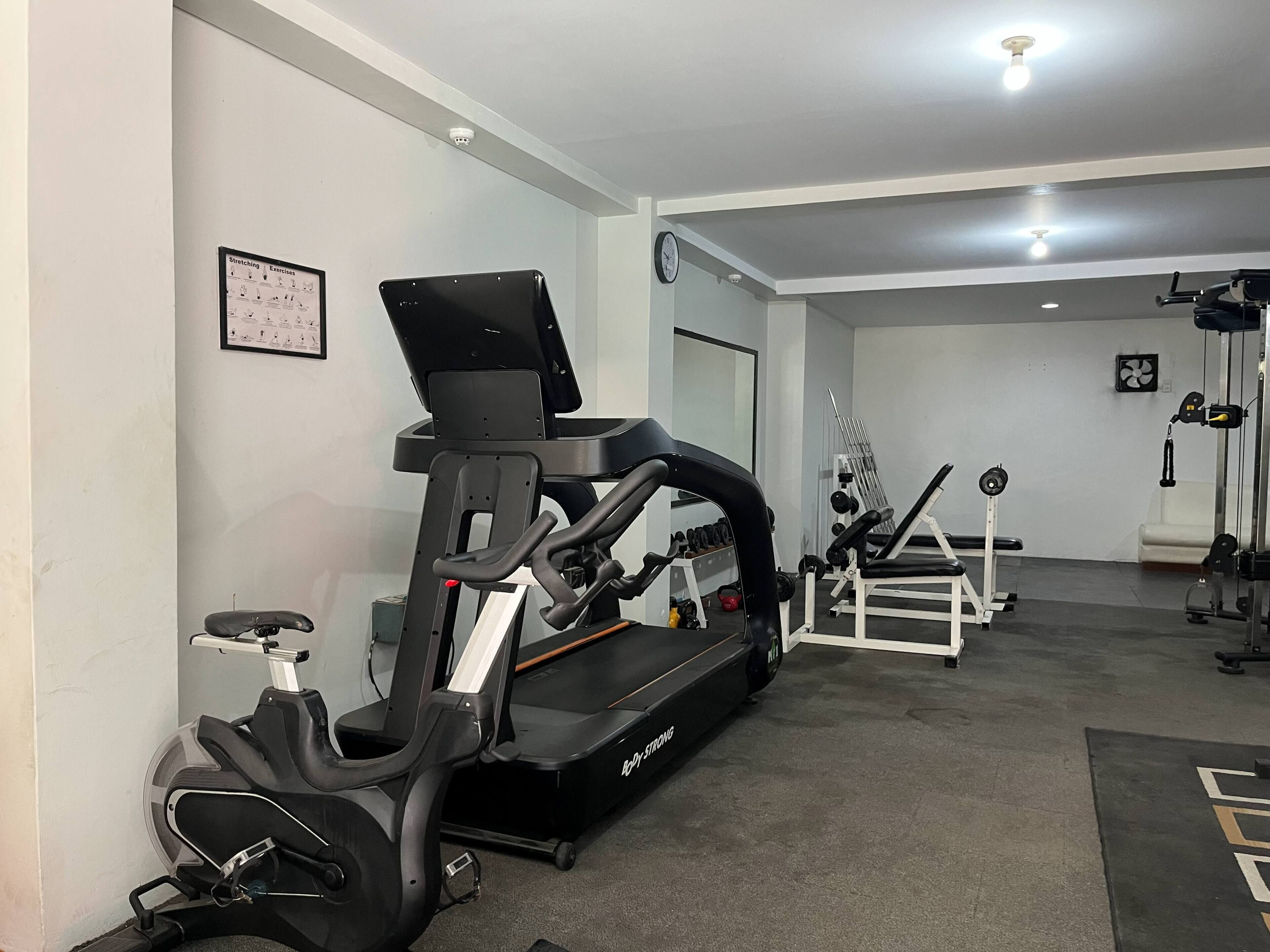 A gym with exercise equipment, including a treadmill and stationary bikes.