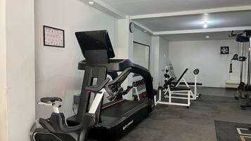 A gym with exercise equipment, including a treadmill and stationary bikes.