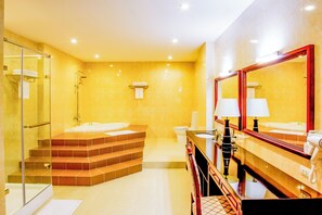 A modern bathroom with a glass shower enclosure, a bathtub, and a vanity with a mirror. - Sai Gon Rach Gia Hotel (Rach Gia)