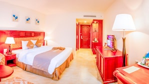 A hotel room with a bed, a chair, a desk, a TV, and a lamp. - Sai Gon Rach Gia Hotel (Rach Gia)