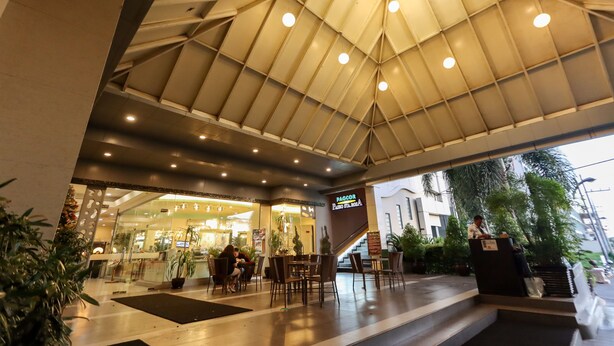 A hotel lobby with a modern design, featuring a large open space with seating and a reception desk. - Paseo Premiere Hotel (Santa Rosa)