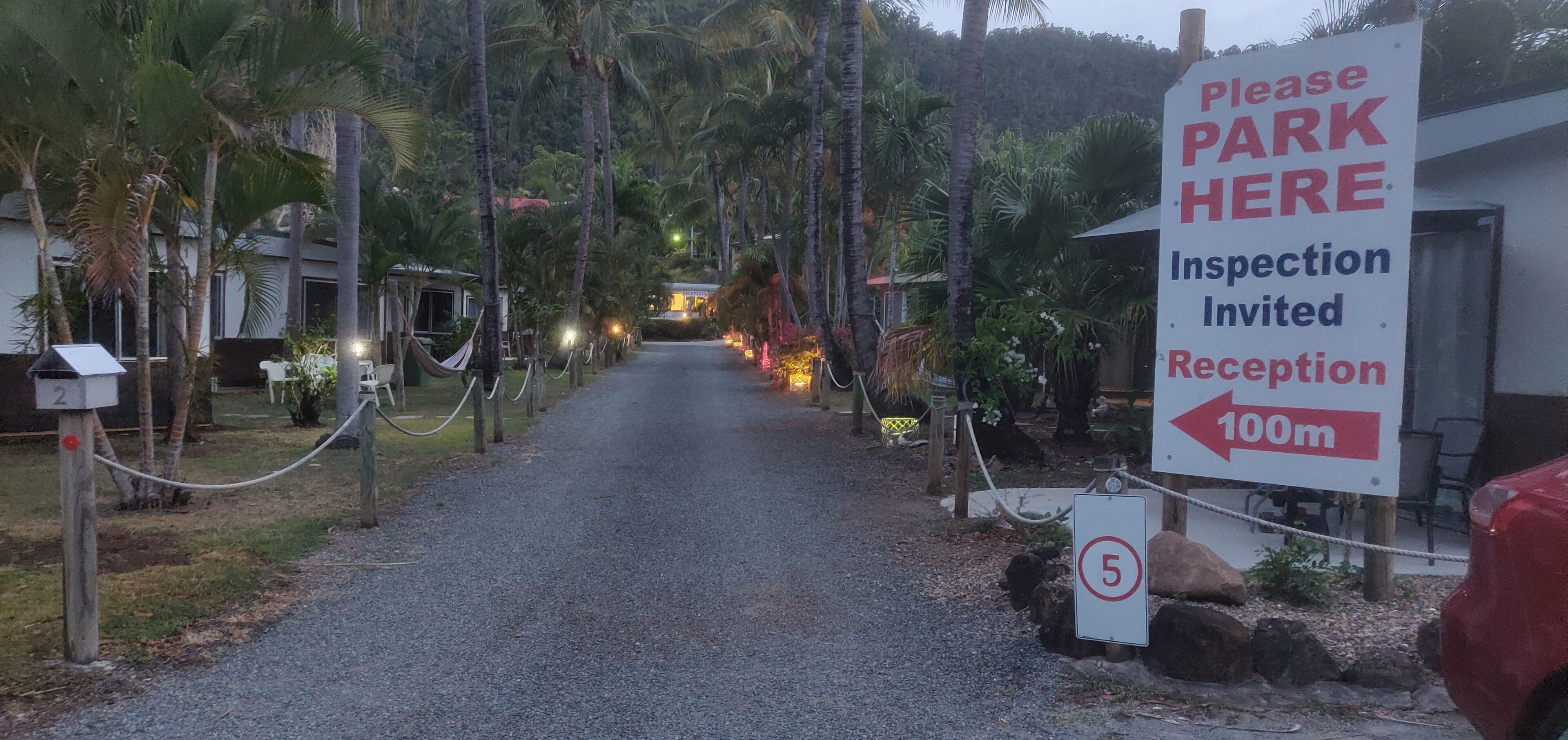 A pathway leading to a reception area with a sign indicating a 100m distance.