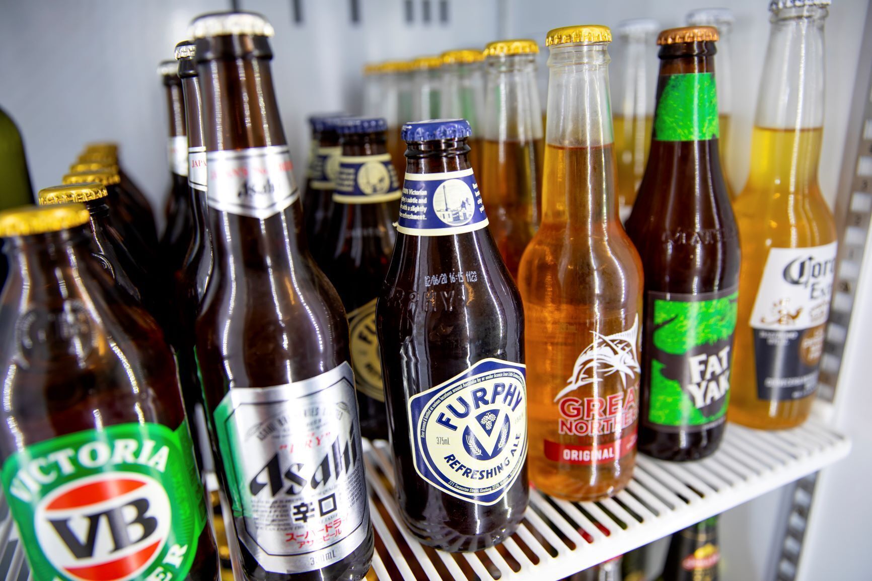 A shelf with various bottles of beverages.