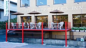 A building with a sign reading "Kyoto Traveler's Inn" and outdoor seating with umbrellas. - Kyoto Travelers Inn (Kyoto)