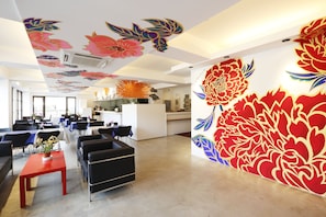 Un interior moderno con un amplio mural floral, una zona de cocina y arreglos de asientos.