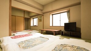 A hotel room with a bed, a TV, a window, and a wooden wardrobe. - Kyoto Travelers Inn (Kyoto)