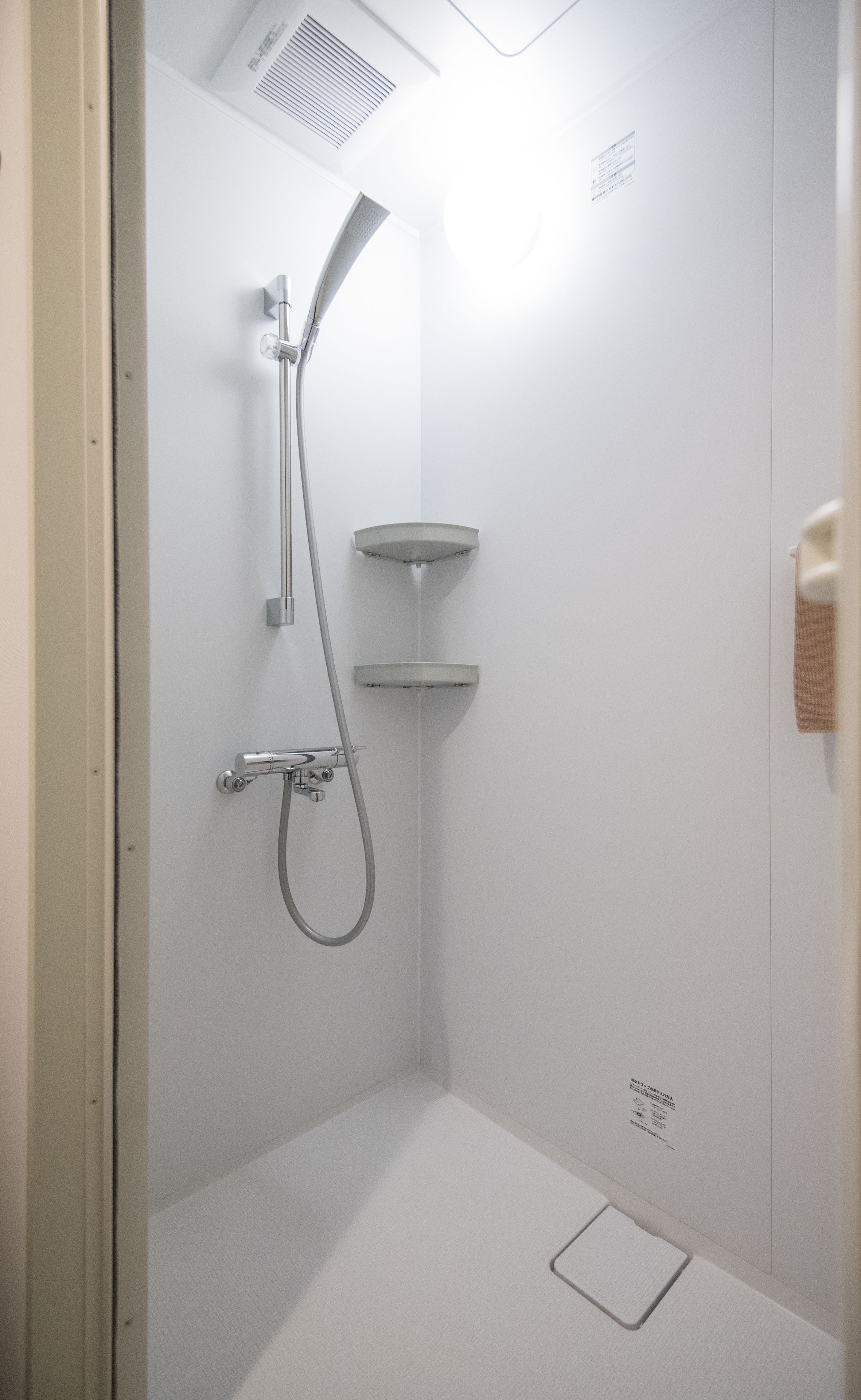 A modern shower with a handheld showerhead and a wall-mounted faucet.