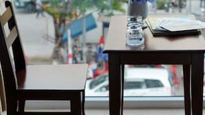 Una mesa con un jarrón de flores, una pila de documentos y un vaso de agua.