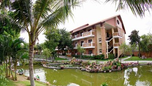 A multi-story hotel with a garden and pond. - Blue Bay Mui Ne Resort & Spa (Mui Ne)