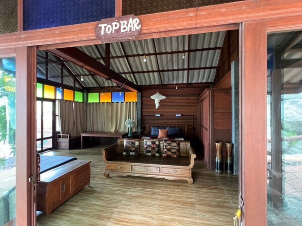 A room with a bed, a wooden cabinet, and a 'Top Bar' sign. - Smile Bungalows (Ko Pha-ngan)