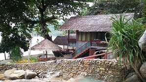 A traditional thatched-roof building with a stone wall and a small pool. - Smile Bungalows (Ko Pha-ngan)