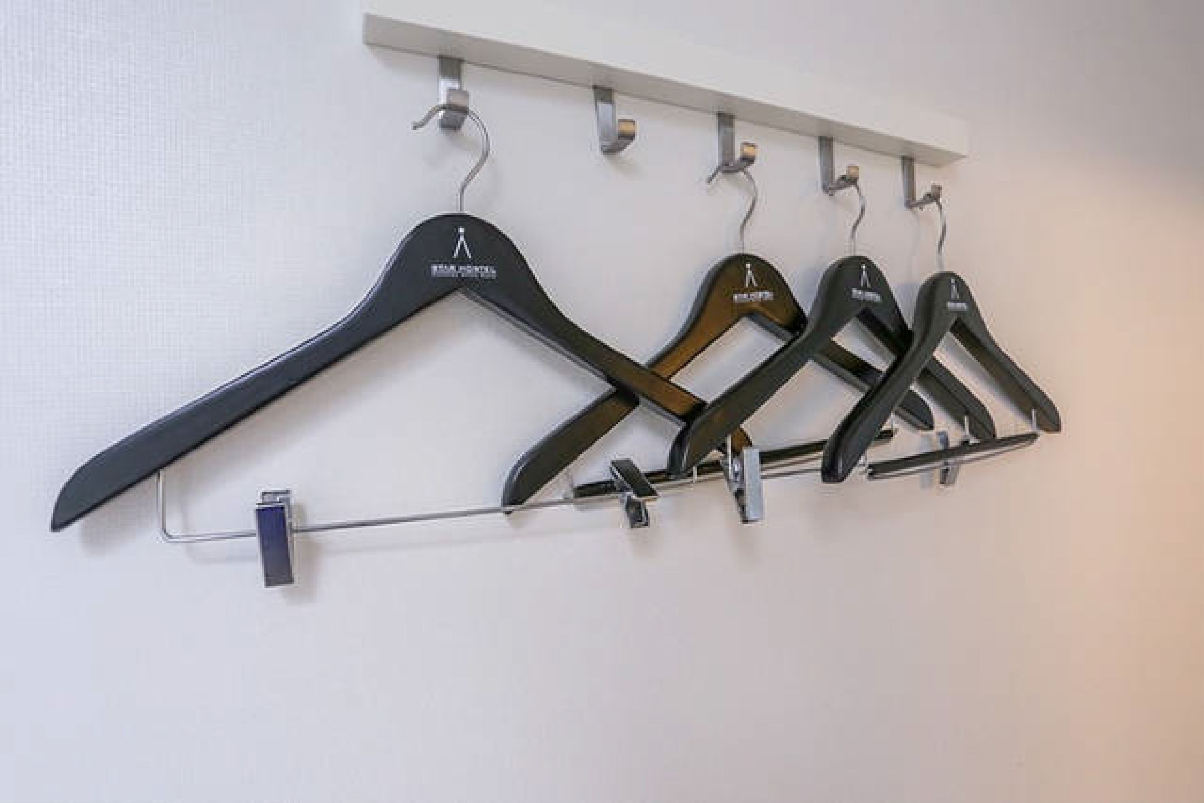 A wall-mounted clothing rack with multiple hangers.