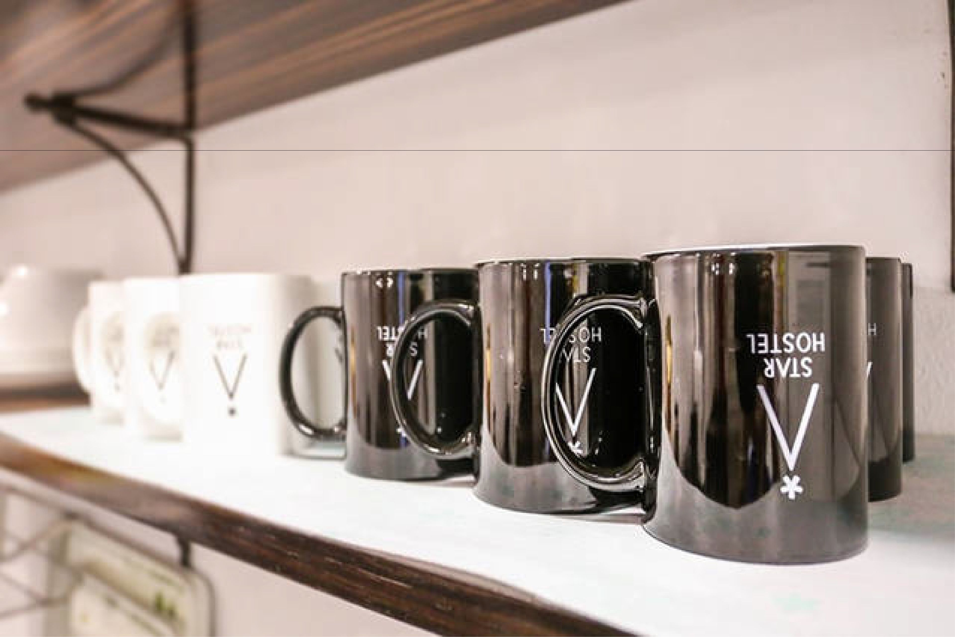 Una hilera de tazas blancas y negras sobre una repisa.