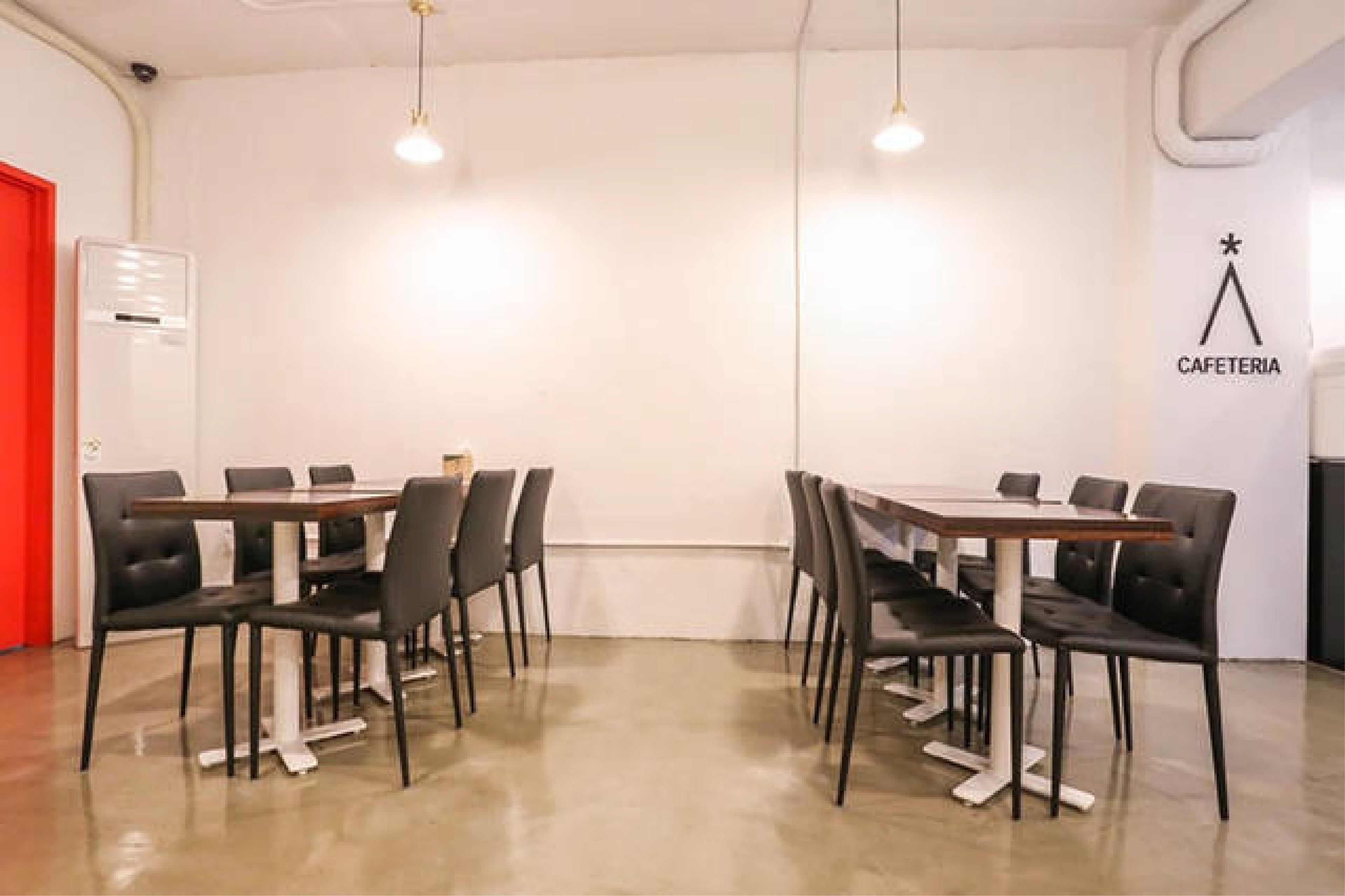 Ett konferensrum med ett långt bord och stolar, en whiteboard och en skylt som visar vägen till en cafeteria.