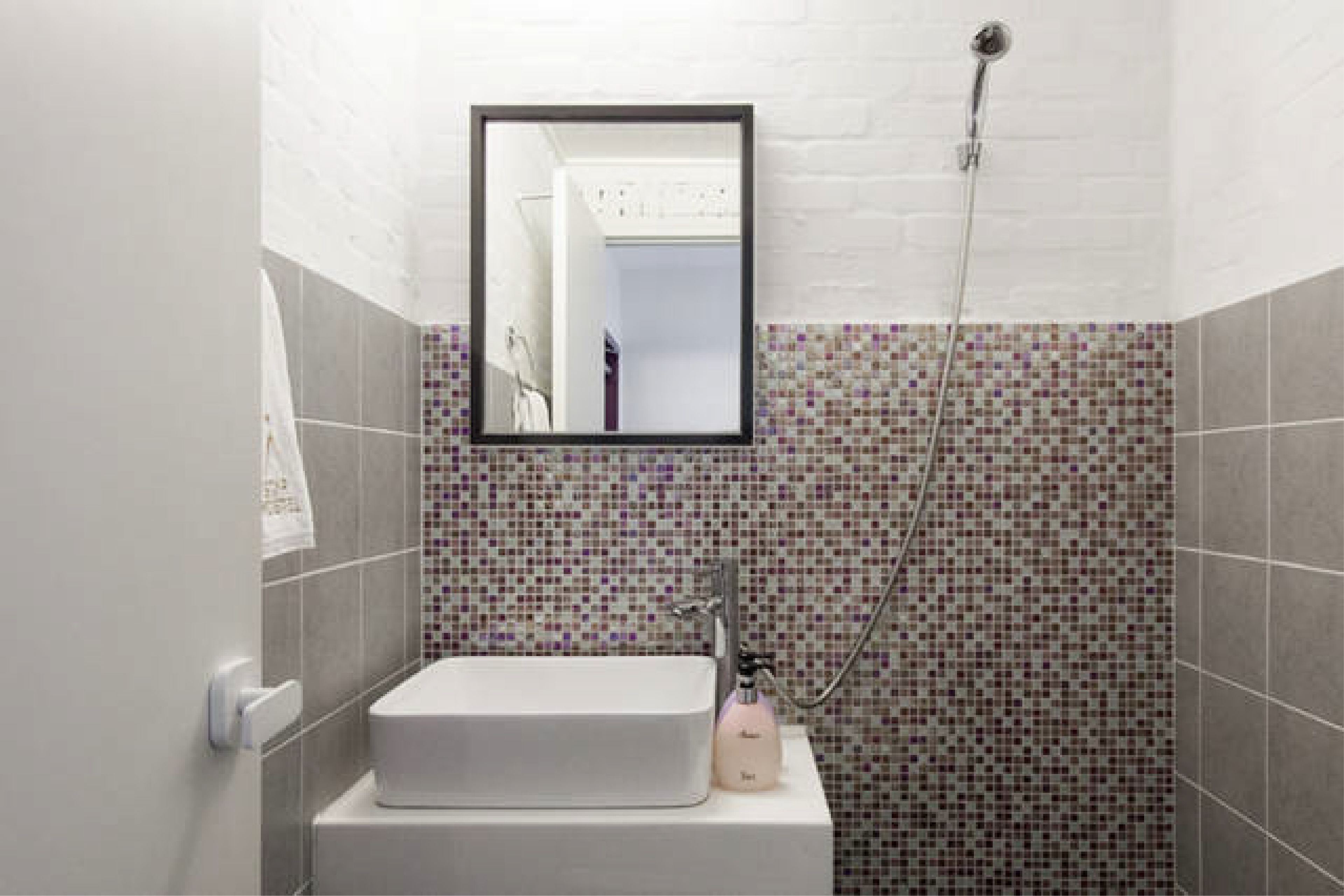 A bathroom with a white sink, a mirror, and a shower.