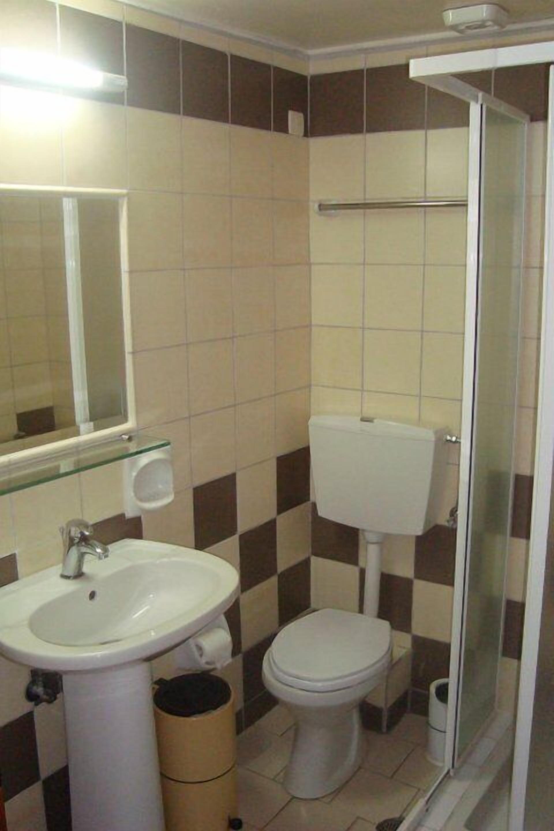 Un baño con lavabo, inodoro y cabina de ducha de vidrio.