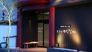 A building with a red exterior and a wooden bench outside. - Hotel Yudanaka (Yamanouchi)