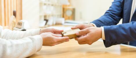 Two hands exchanging a small wooden box.