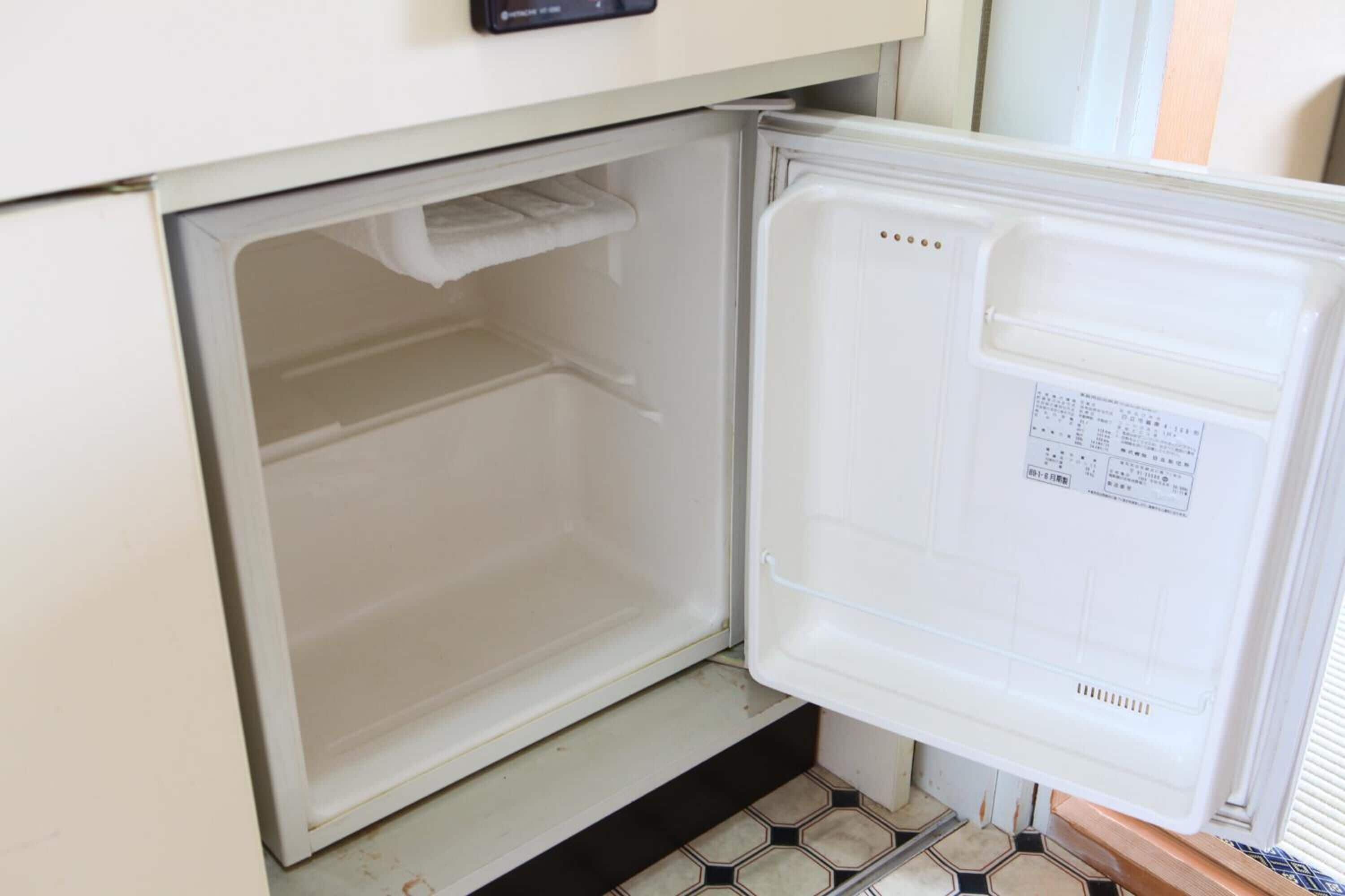 A compact refrigerator with a control panel on top, built into a kitchen counter.