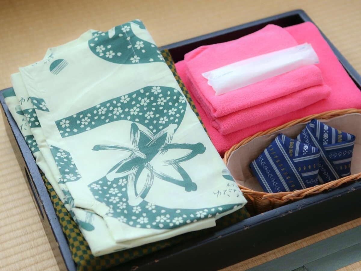 Eine schwarze Box mit gefalteten Handtüchern, einem weißen Taschentuch und einem Korb mit gefalteten Handtüchern.