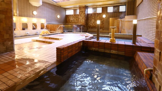 A hot tub area with tiled flooring, a brick wall, and a skylight. - Hotel Yudanaka (Yamanouchi)
