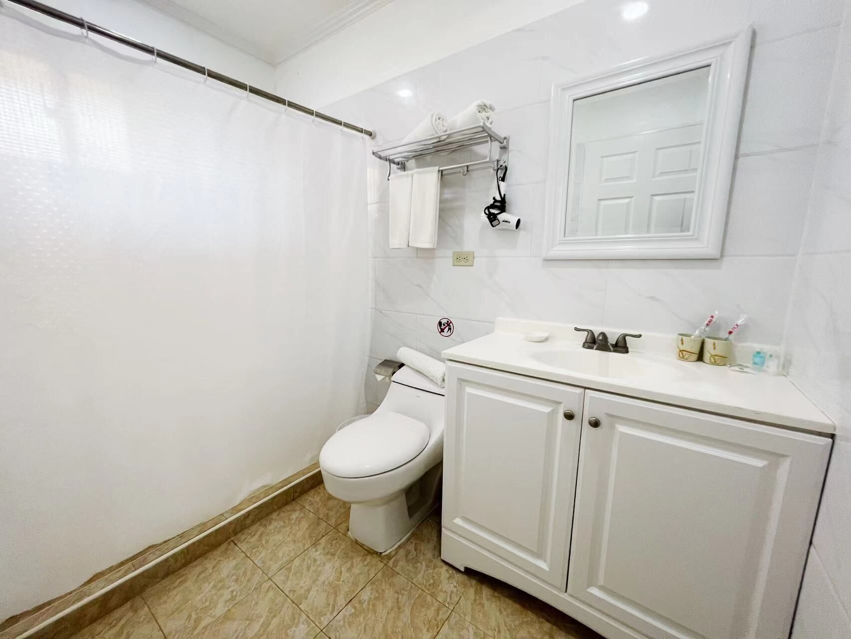 A bathroom with a toilet, sink, and mirror.