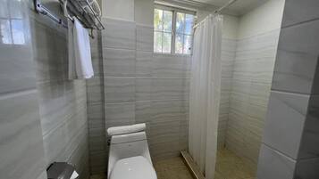 A small, modern bathroom with a toilet, a towel rack, and a shower curtain.