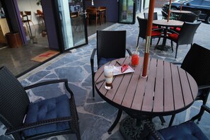 Relax in a cozy outdoor seating area with a round table and comfortable chairs.