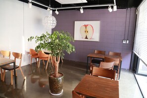 Enjoy dining in this stylish space with a large potted plant, wall-mounted light fixture, and framed artwork.